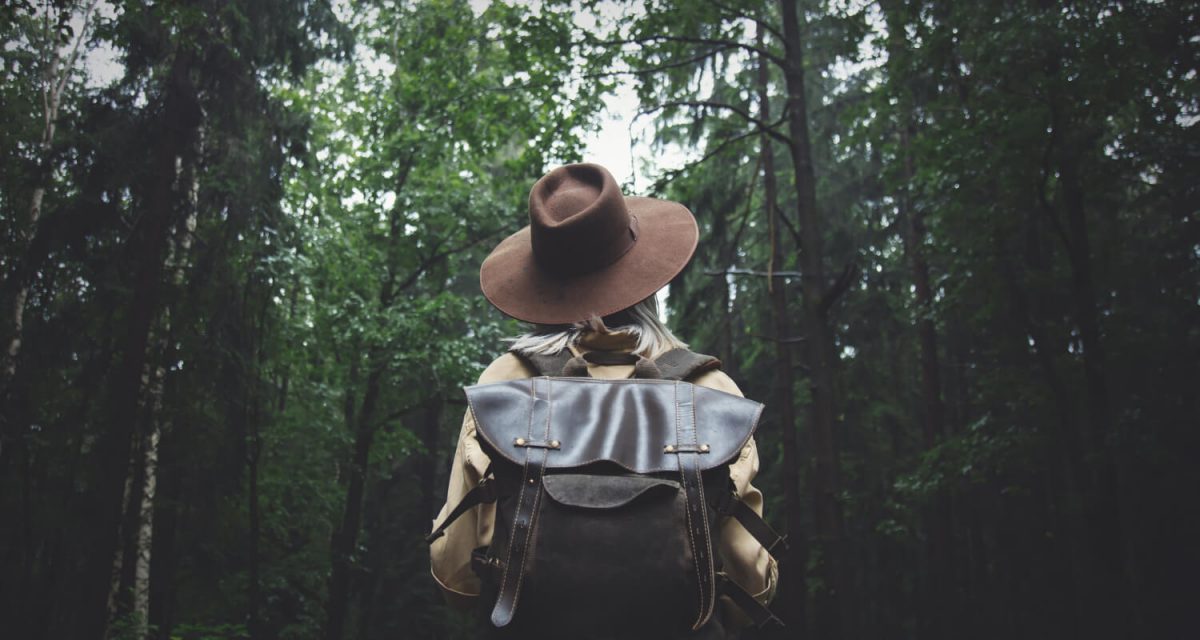 blonde-woman-in-hat-with-backpack-in-rainy-day-in-forest-1.jpg